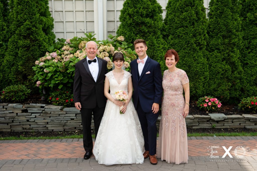 Bride and groom with parents outside