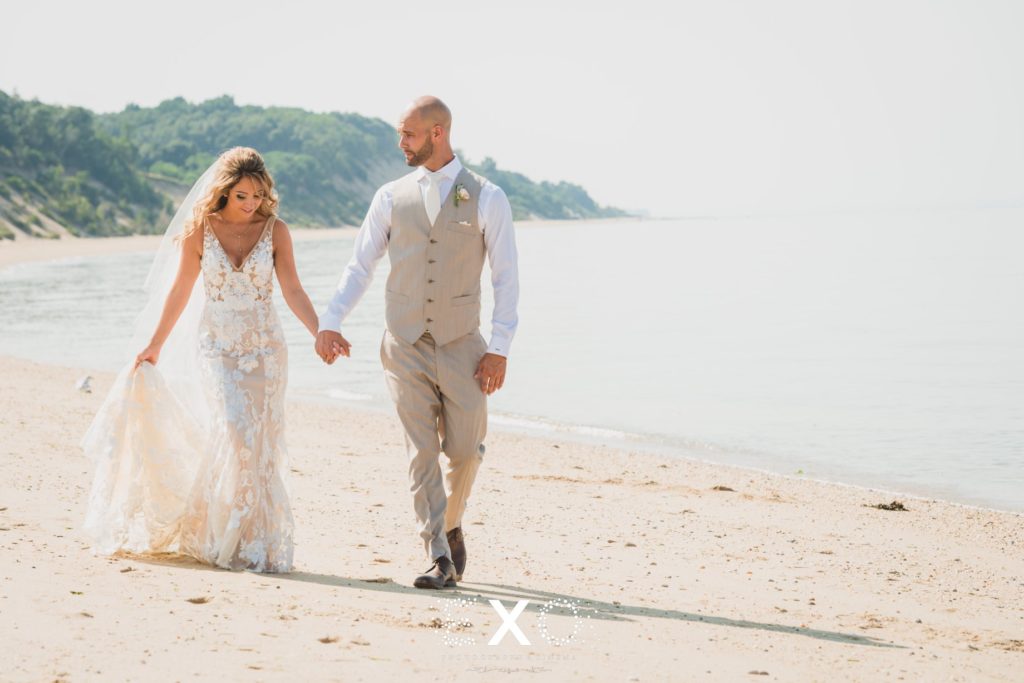 bride and groom walking along the shore at Pavilion at Sunken Meadow
