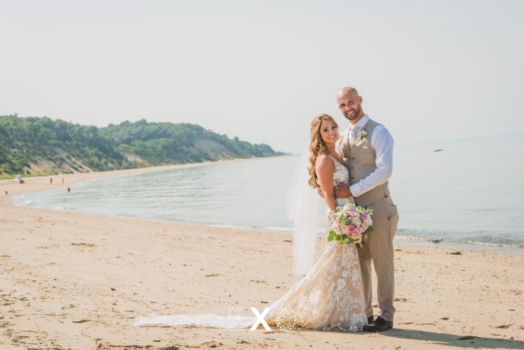bride and groom posing on the shore at Pavilion at Sunken Meadow