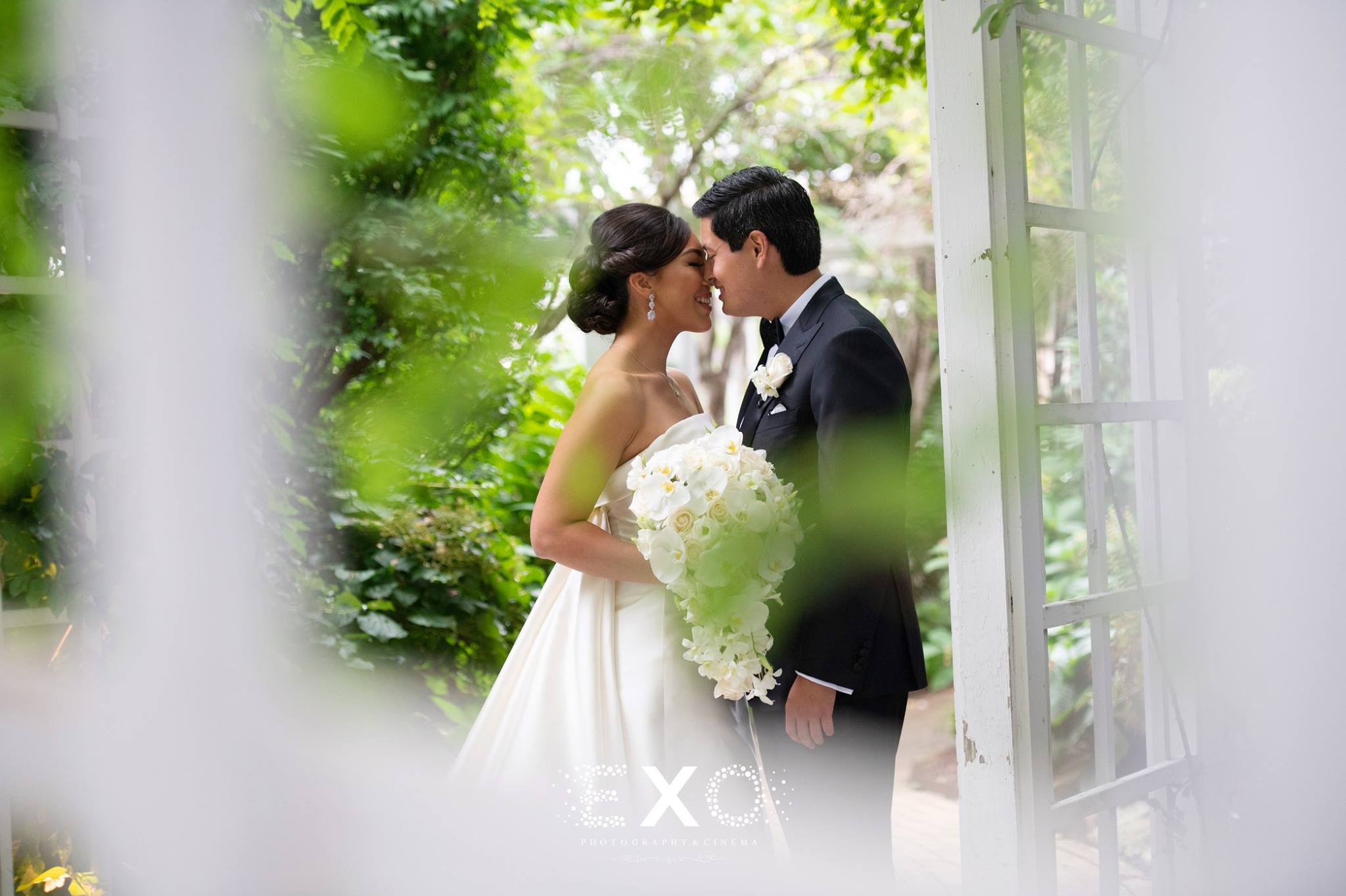 Bride and groom kissing outside
