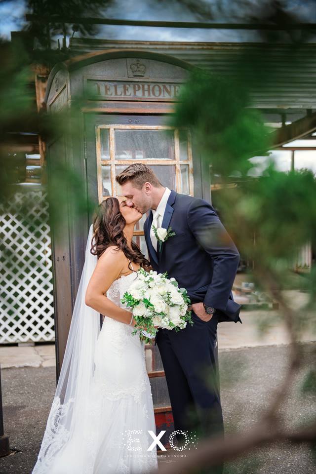 Bride and groom kissing outside the old telephone booth