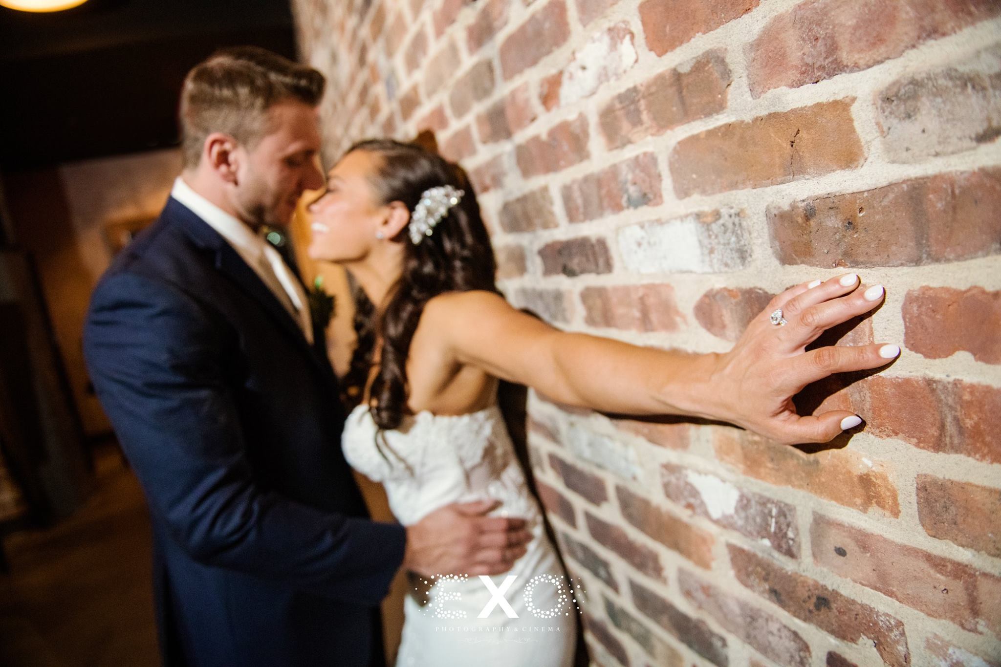bride and groom kissing against the wall at The Loft at Bridgeview Yacht Club