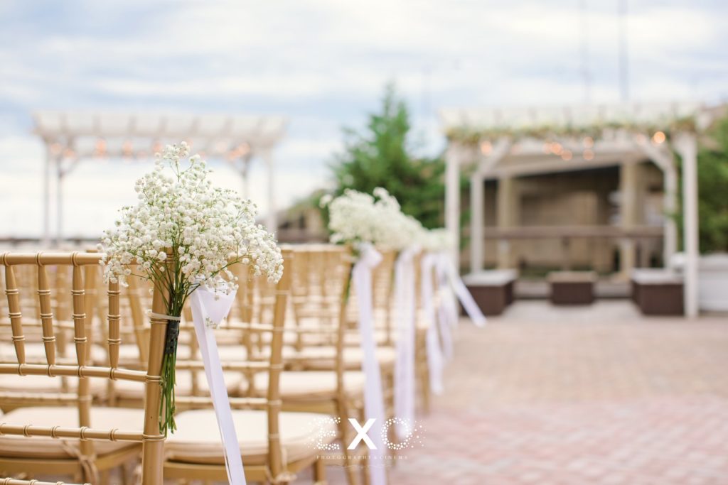 floral arrangements on guests chairs during ceremony at The Loft at Bridgeview Yacht Club