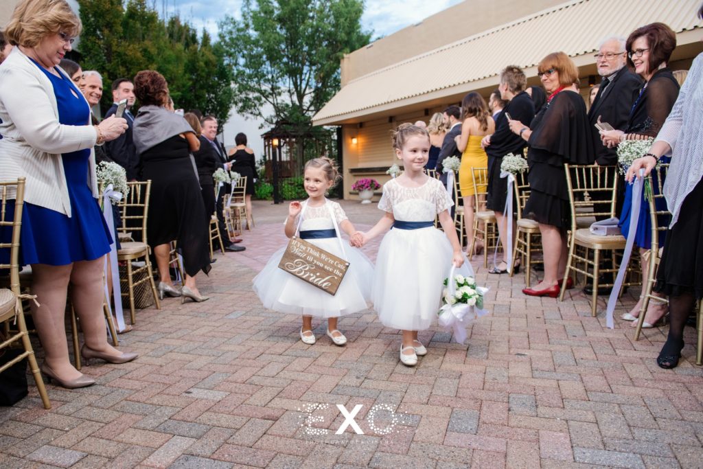 Flower girls walking down the aisle at The Loft at Bridgeview Yacht Club