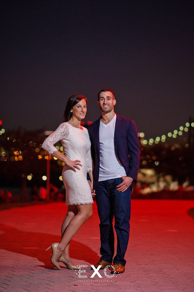 couple posing with red light behind them