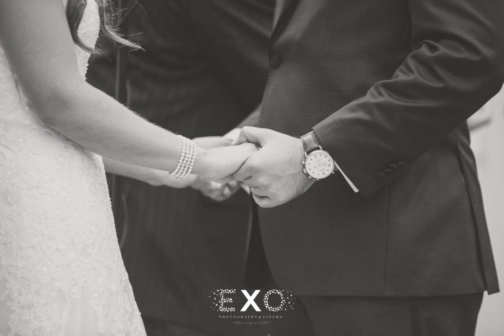 bride and groom holding hands during the ceremony at Harbor Club at Prime
