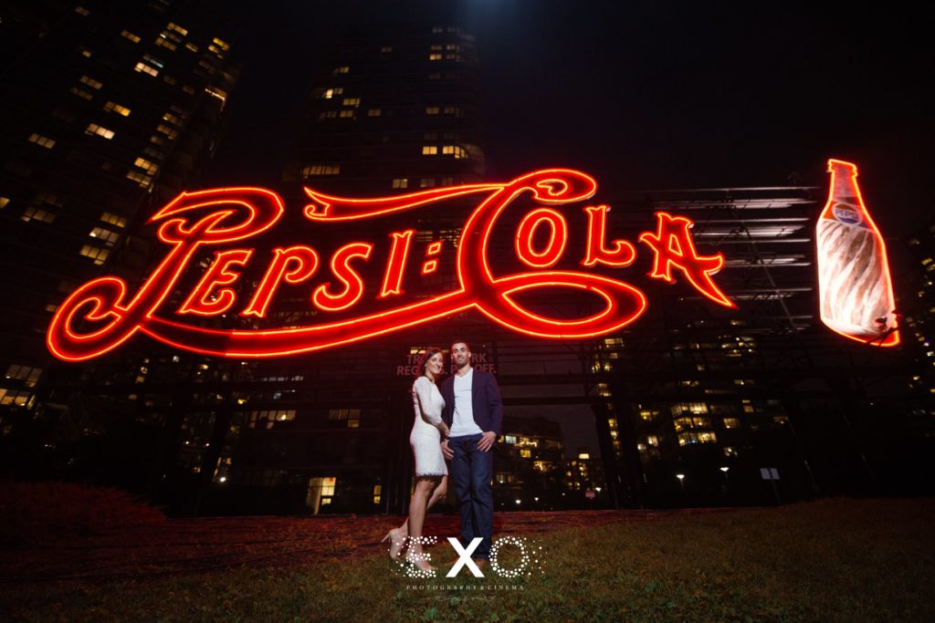 couple posing under the pepsi sign at Gantry Plaza State Park