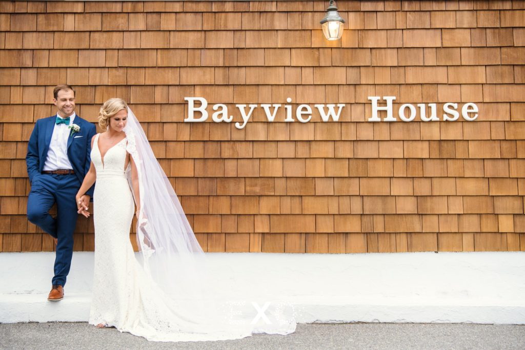 bride and groom posing in front of bayview house sign at Captain Bills