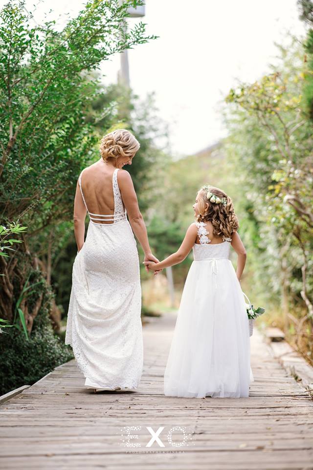bride and flower girl holding hands