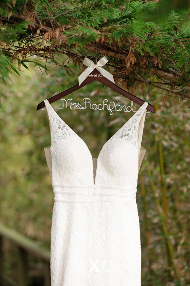 brides dress hanging outside on personalized hanger