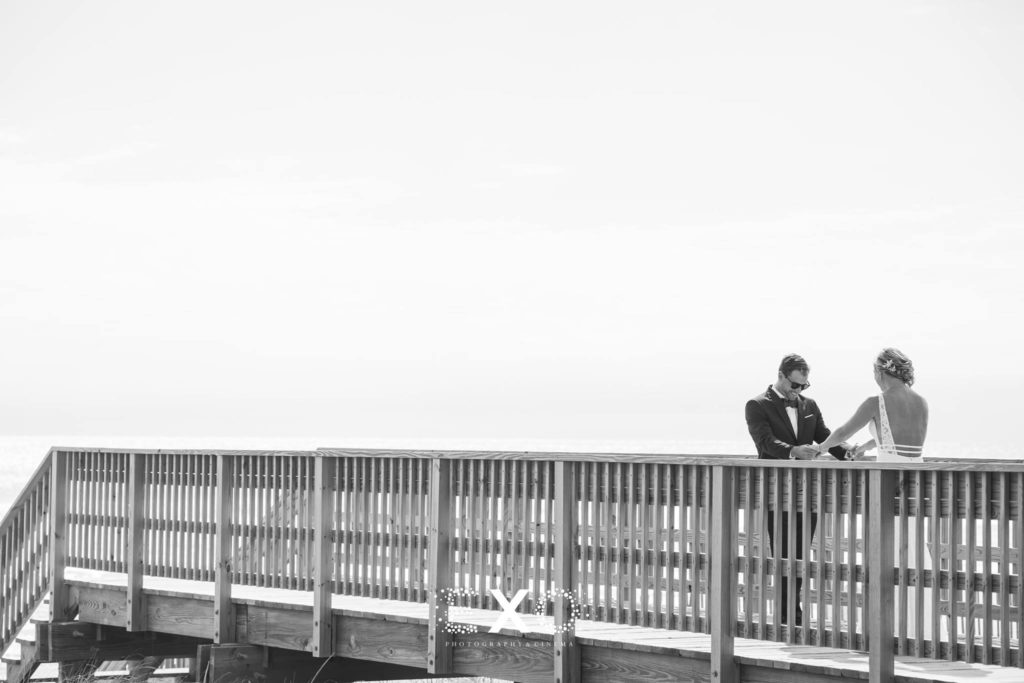 groom looking at bride on bridge