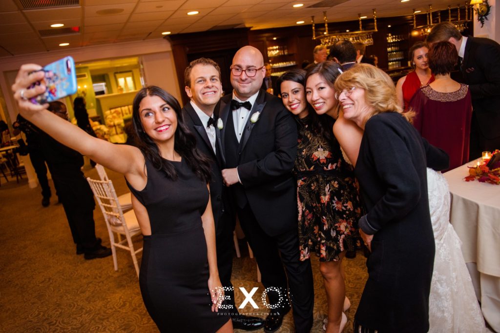 bride and groom with guests taking selfie at North Shore Country Club