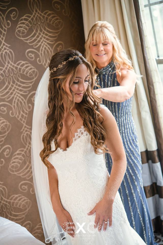 bride getting help putting her dress on at Harbor Club at Prime