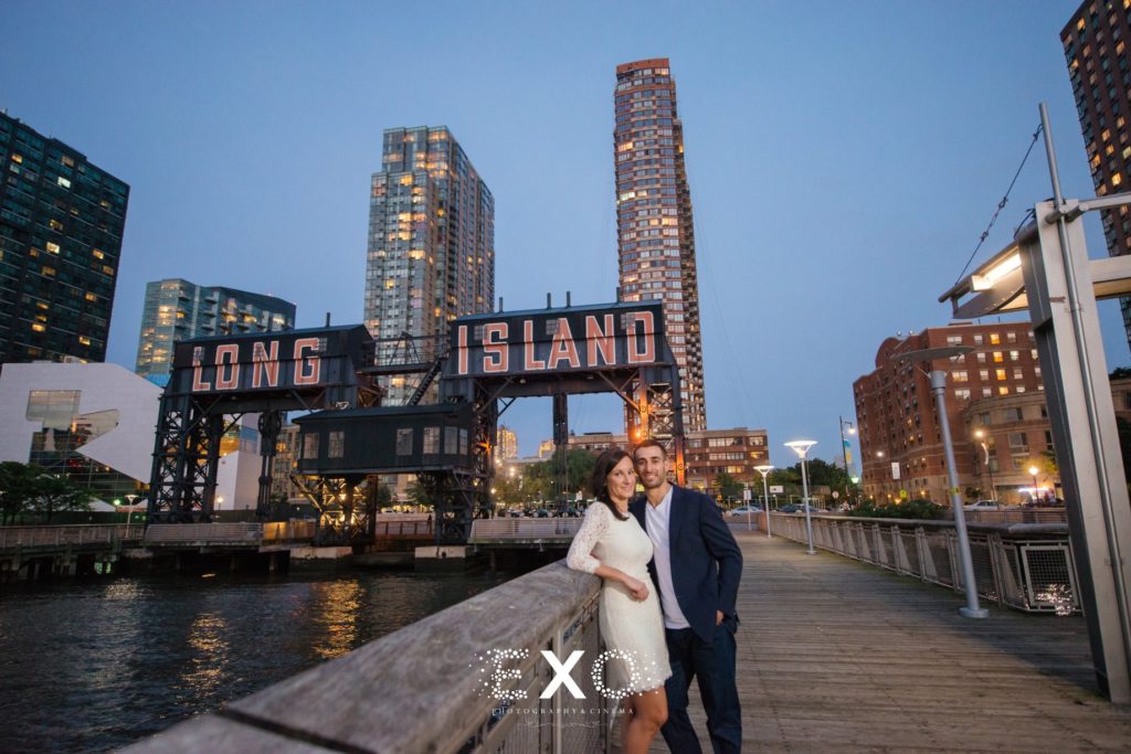 couple standing under long island sign at Gantry Plaza State Park