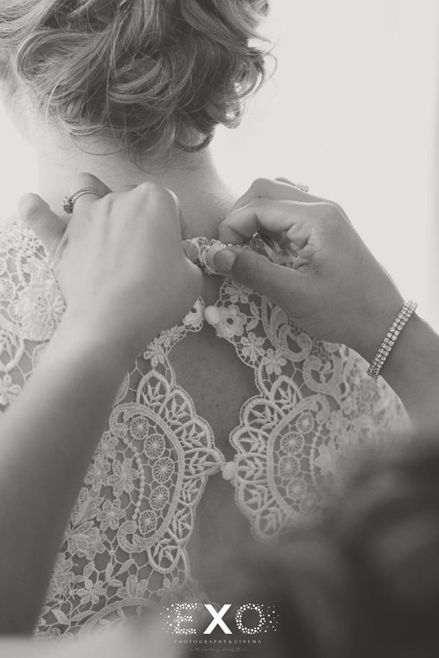 bride getting dress buttoned at Willow Creek Golf and Country Club