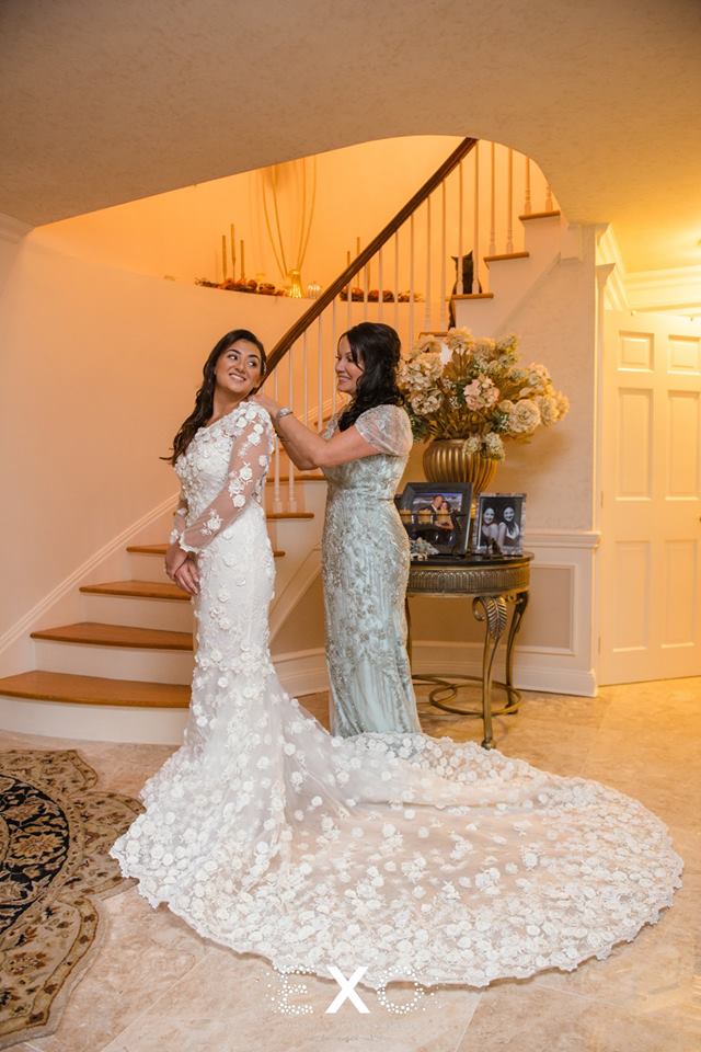 bride getting her dress zipped by her mother at The Mansion at Oyster Bay