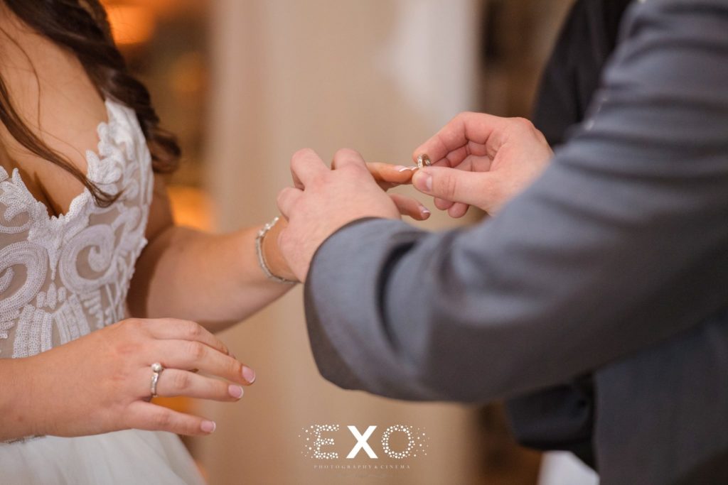 groom putting ring on brides finger at fox hollow