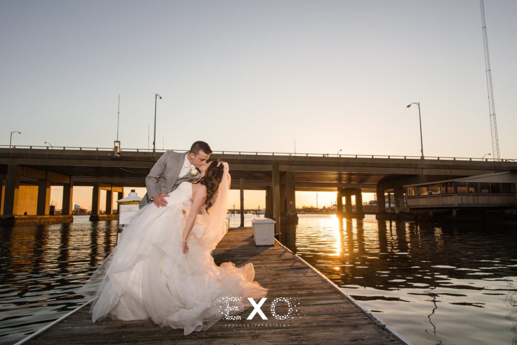 Bride and groom kissing on dock at Bridgeview Yacht Club