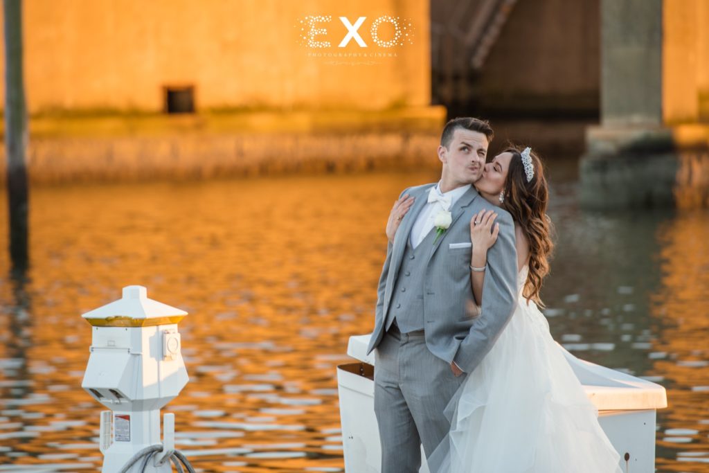bride kissing groom on dock at Bridgeview Yacht Club