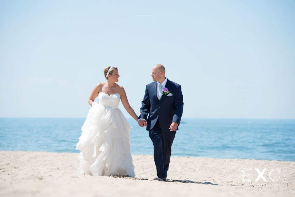 bride and groom walking along the beach