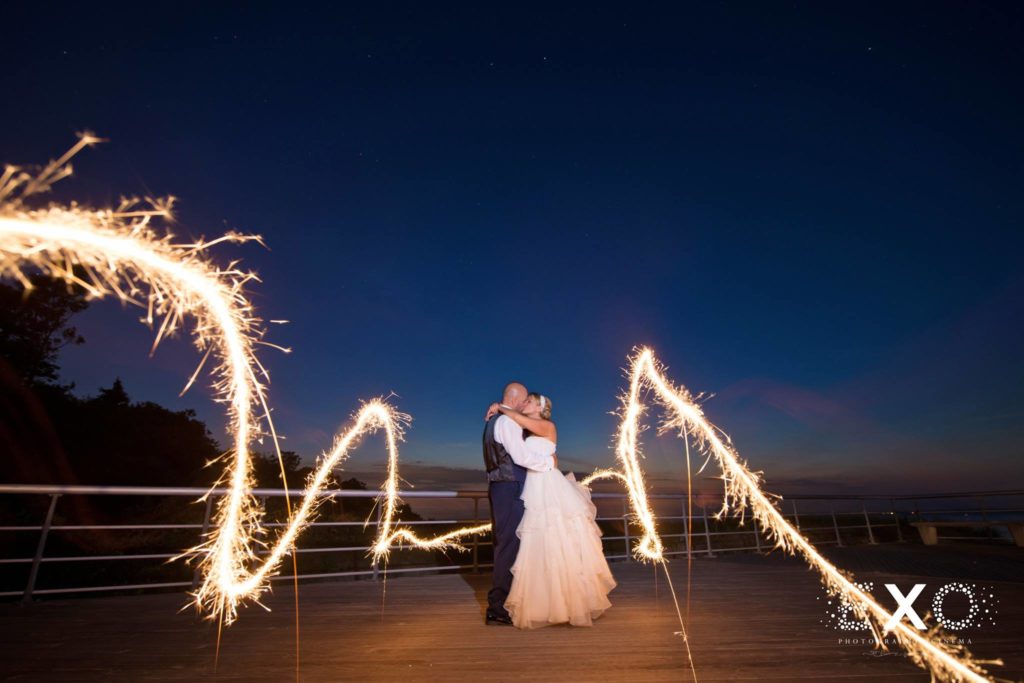 bride and groom on boardwalk at night with lights