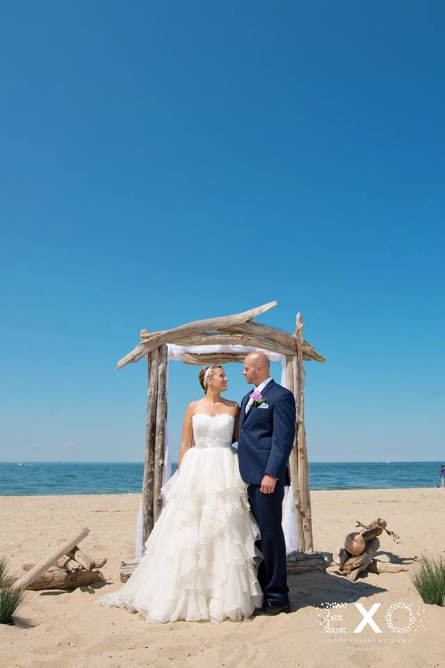 bride and groom standing under arch at Pavilion at Sunken Meadow