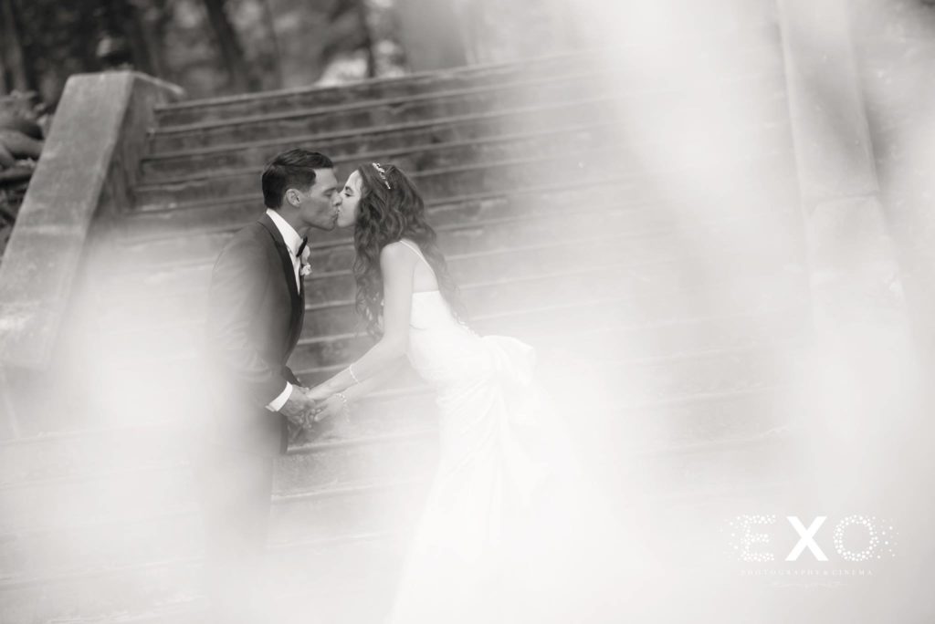 bride and groom kissing at steps in black and white at Villa Russo