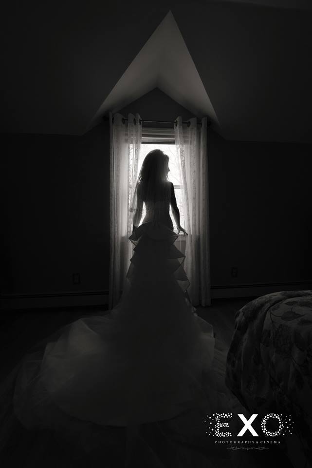 bride all dressed up standing by window