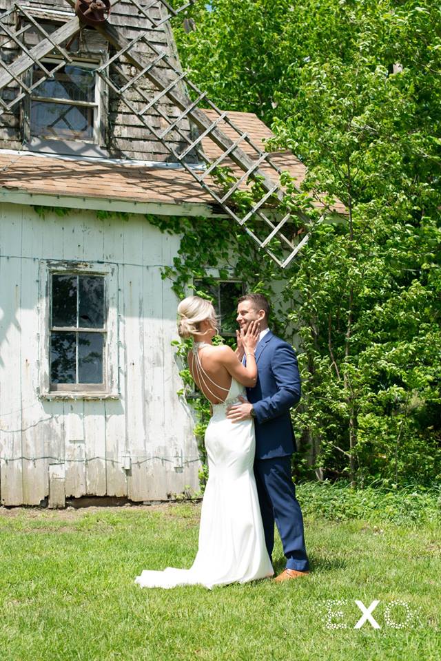 bride holding groom's face in front of windmill