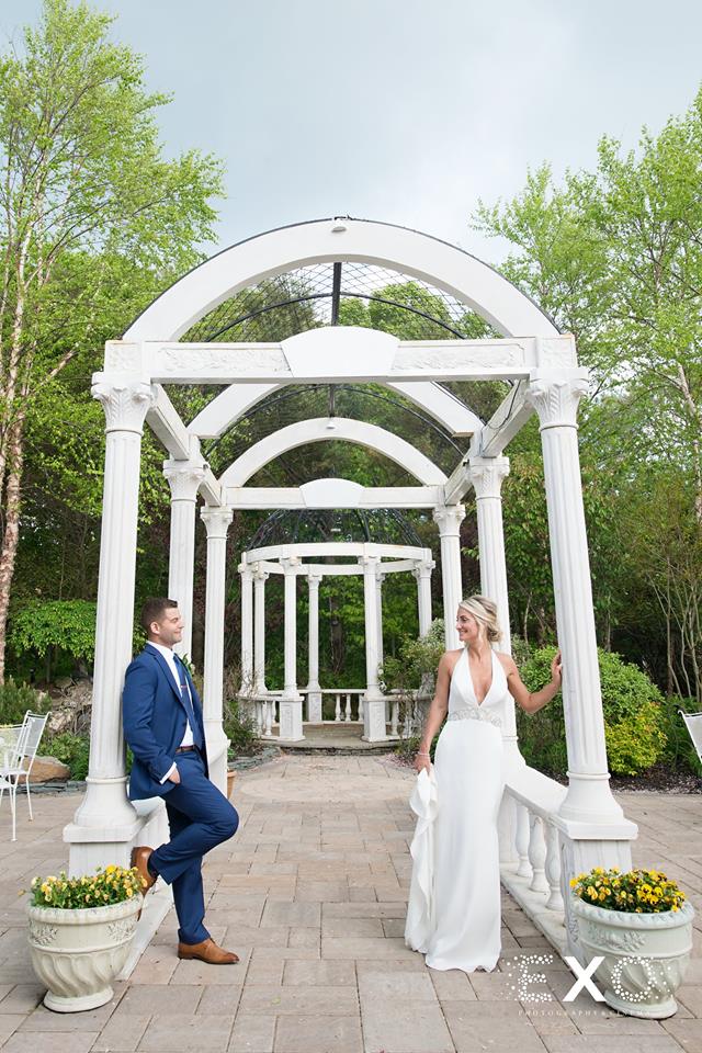 bride and groom posing under archway