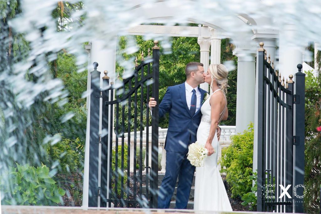 bride and groom kissing by the gate