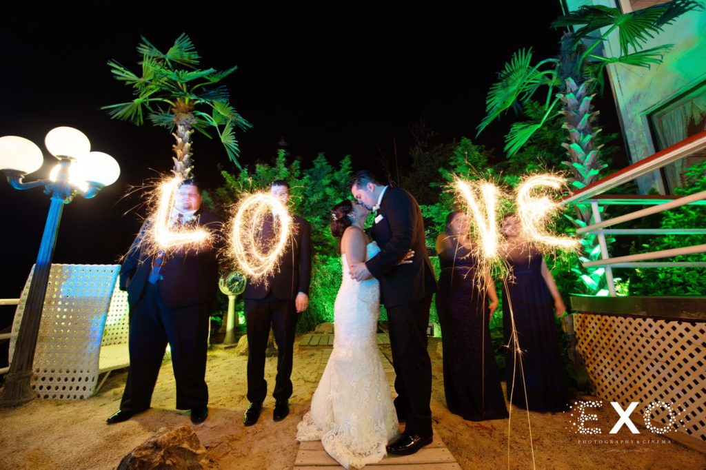 bride and groom kissing with love sparklers
