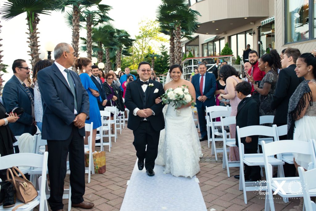 bride and her father walking down the aisle at Chateau La Mer