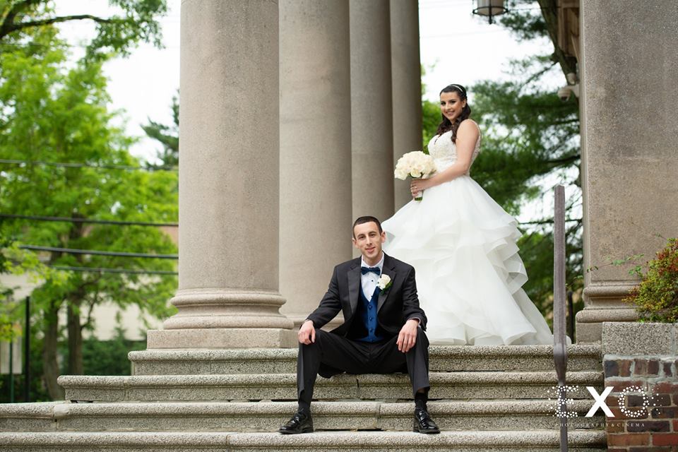 bride and groom posing outside Temple Beth El Cedarhurst