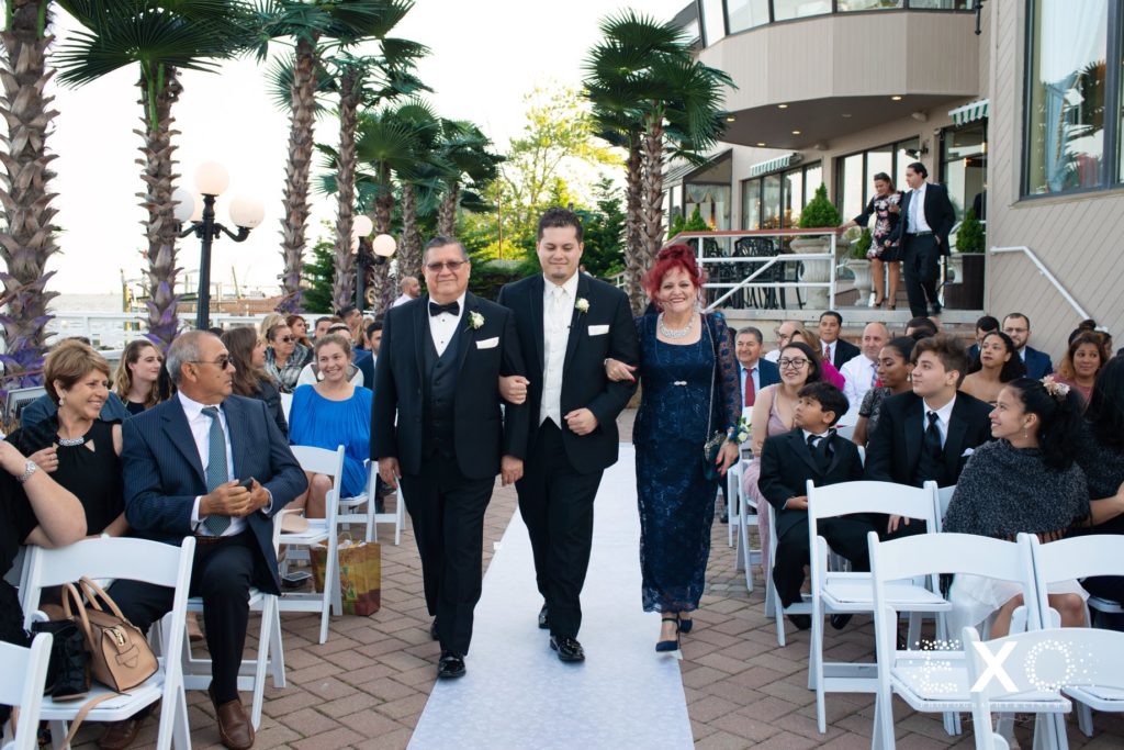groom walking down the aisle with his parents at Chateau La Mer