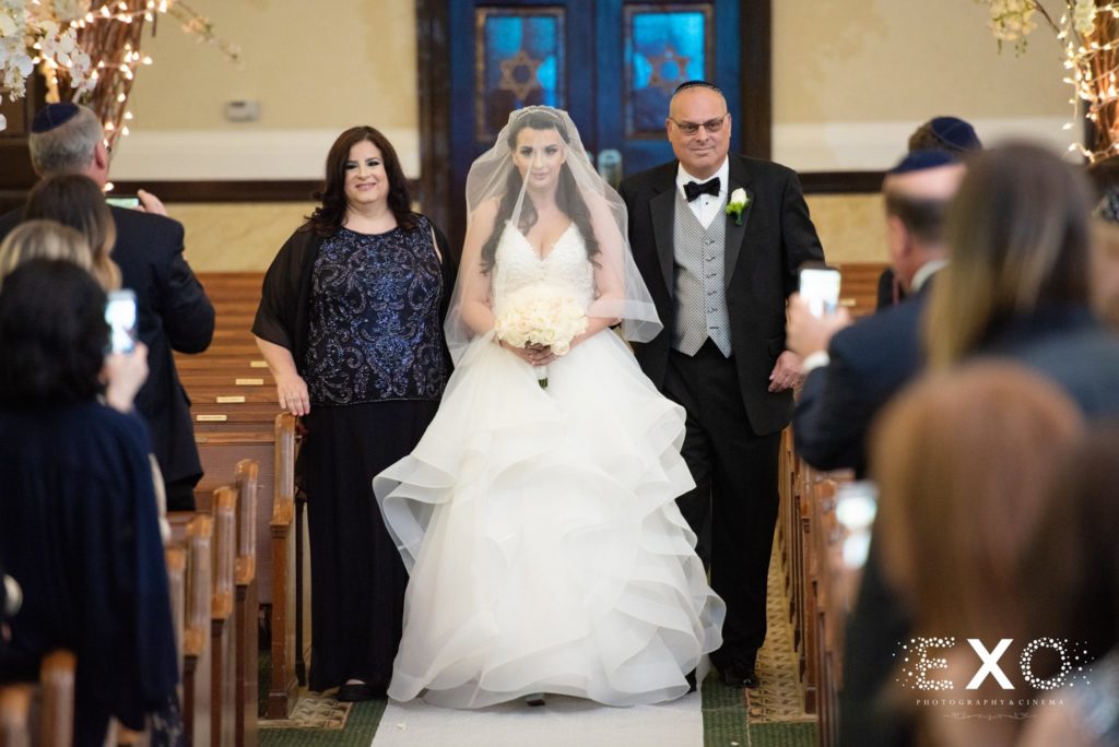bride walking down the aisle with her parents at Temple Beth El Cedarhurst