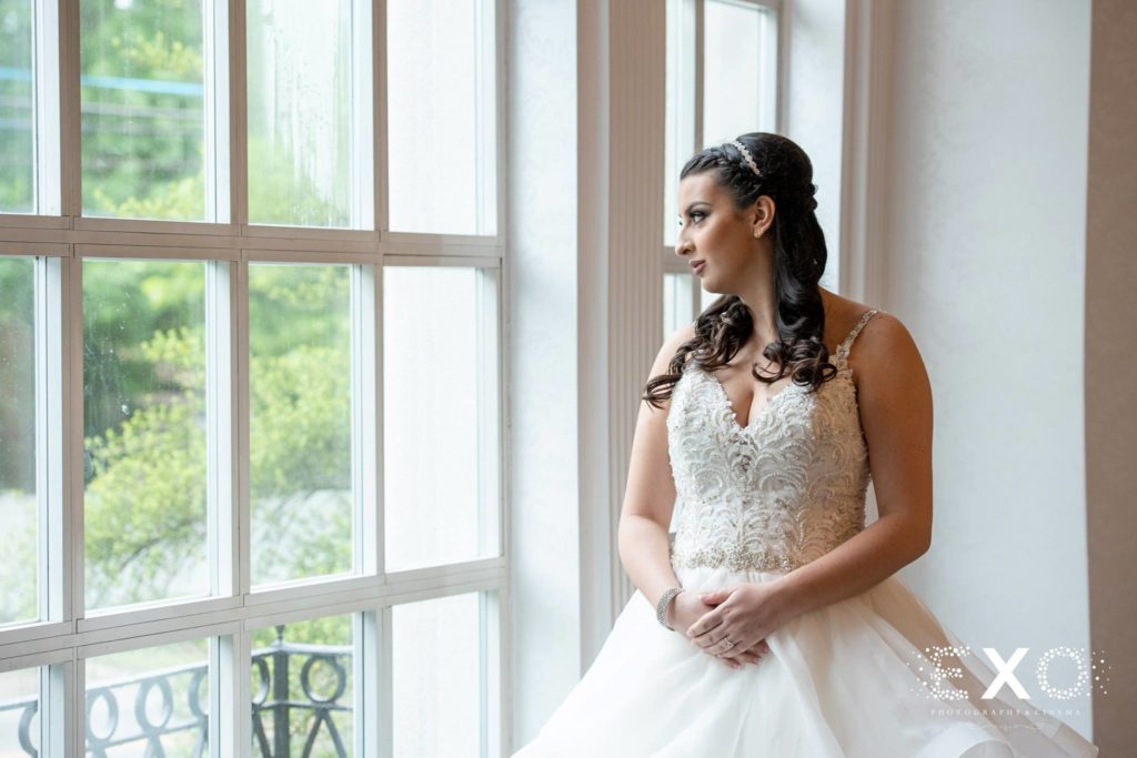 bride looking out the window at Temple Beth El Cedarhurst