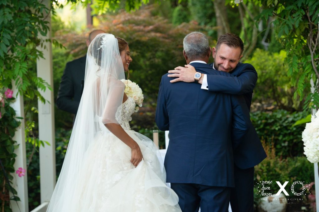 groom hugging bride's father at Fox Hollow