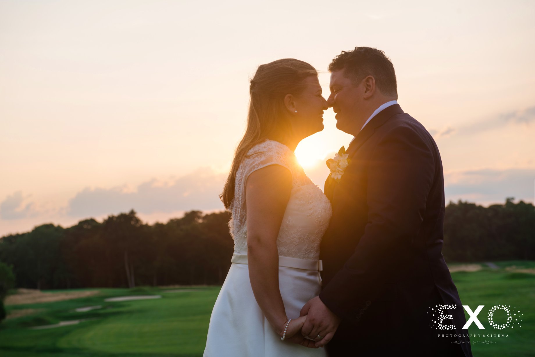 bride and groom kissing during sunset at Huntington Country Club