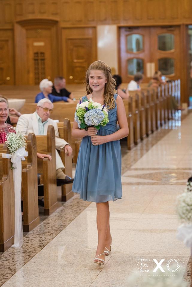 junior bridesmaid walking down the aisle