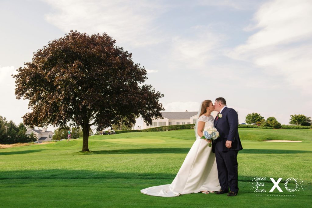 bride and groom kissing on the golf course at Huntington Country Club