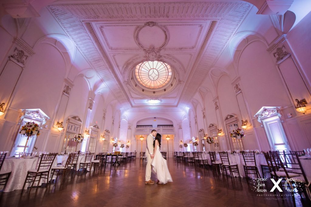 bride and groom kissing in ballroom