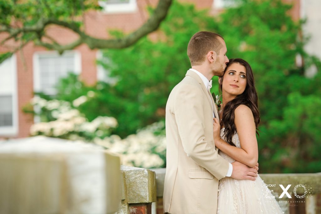 groom kissing his bride at Bourne Mansion