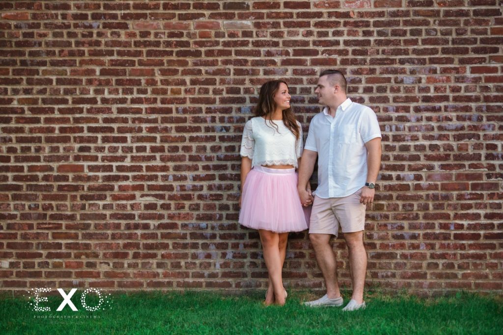 couple standing against the brick wall