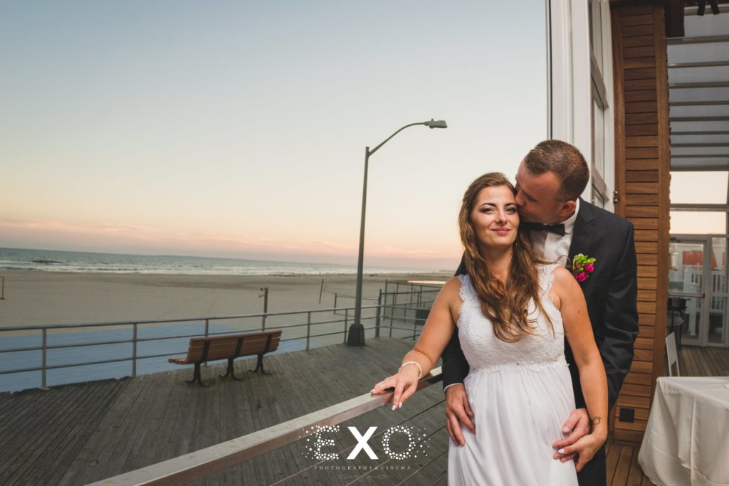 bride and groom posing on the boardwalk at Sunny Atlantic Beach Club
