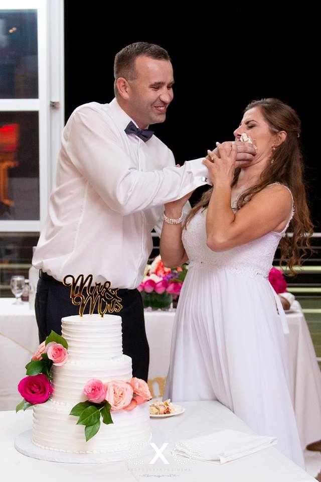 groom putting cake on bride's face at Sunny Atlantic Beach Club