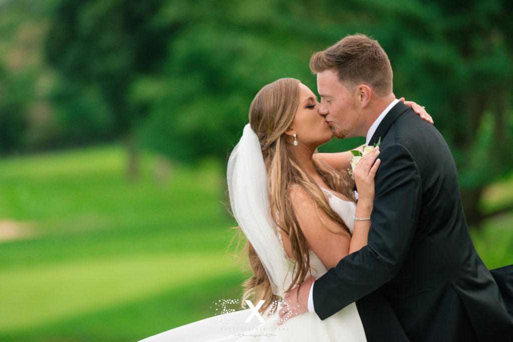 bride and groom kissing outside Stonebridge Country Club