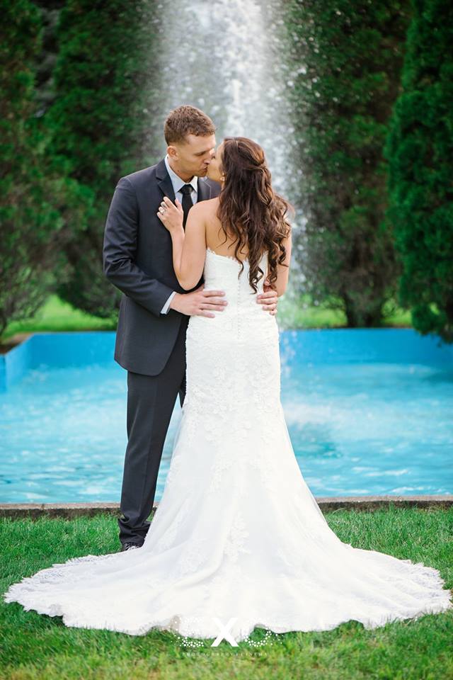 bride and groom kissing by the pool