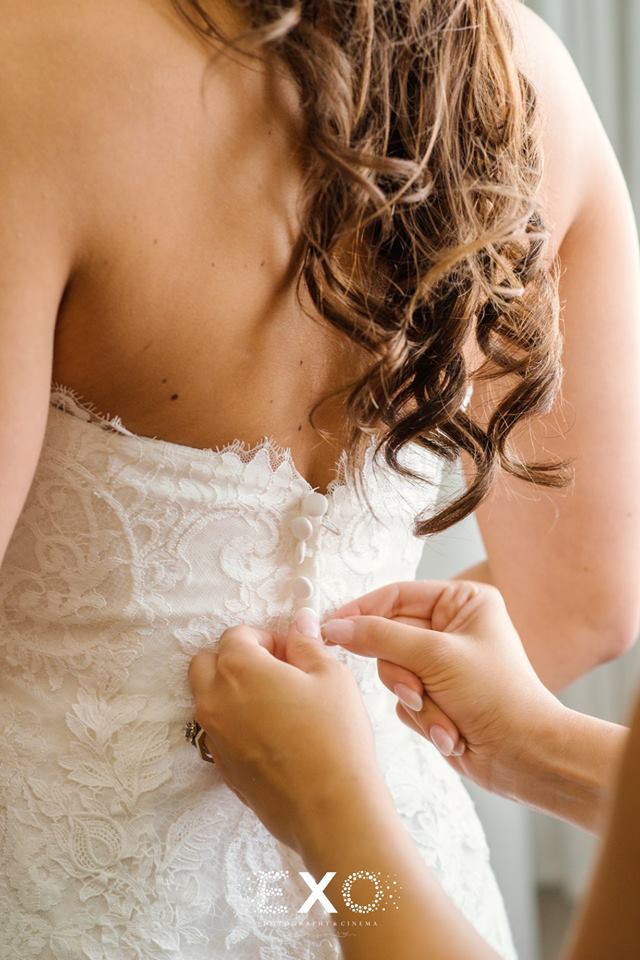 bride getting her dress buttoned up