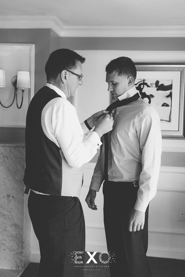 groom getting help with his tie at The Carltun